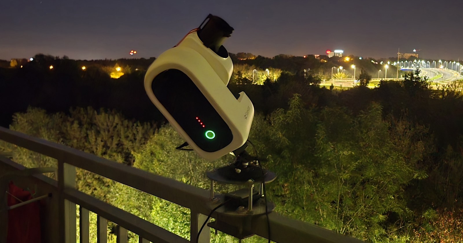 Teleskop Seestar S50 Pro na balkonie w Rzeszowie nocą, w tle światła miasta
